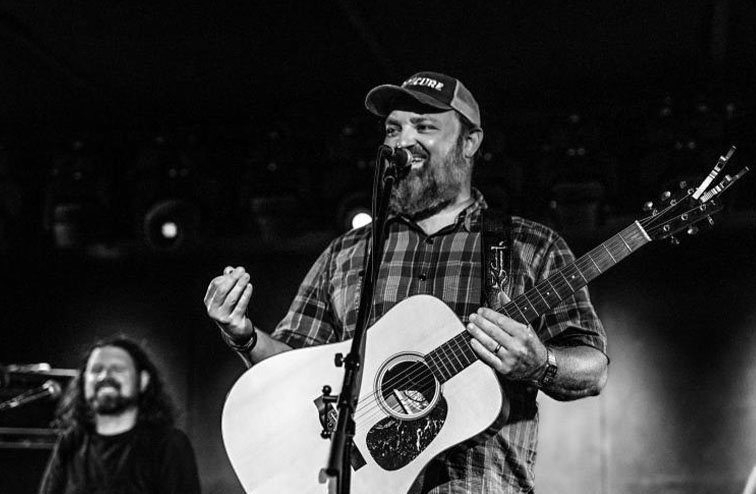 John Driskell Hopkins playing guitar on stage during a concert